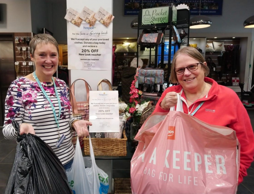 This button takes you to a page about where to donate goods to St Richard's shops. The image shows two smiling people standing together holding bags of donations.