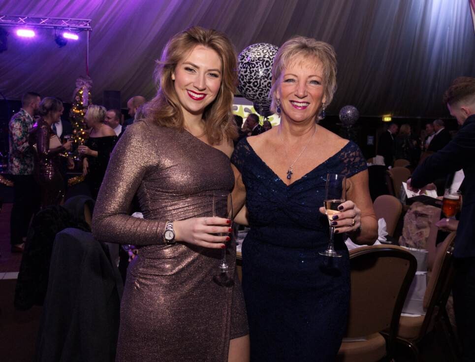Two people in glamorous evening dresses at the St Richard's Hospice Snowdrop Ball.