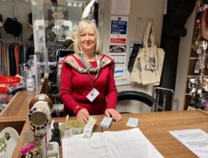 Volunteer standing behind shop counter