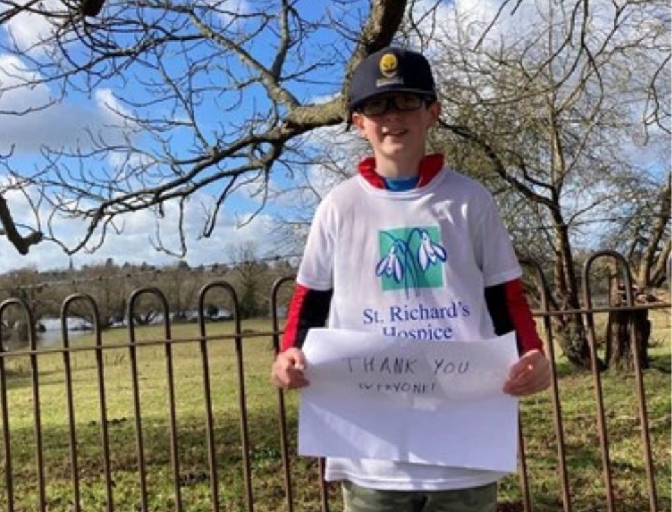 Eddie wearing a white tshirt with hospice logo and holding a thankyou everyone sign