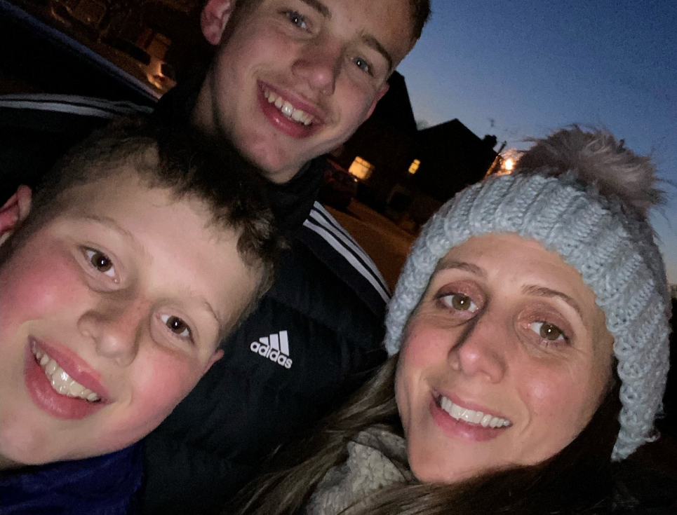 Liam, Jay and Sabrina Ingram pictured at dusk out on a fundraising walk. Sabrina is wearing a grey, woolly bobble hat.