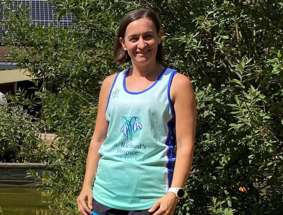 Aly in the gardens at St Richard's Hospice wearing a St Richard's Hospice branded running vest.