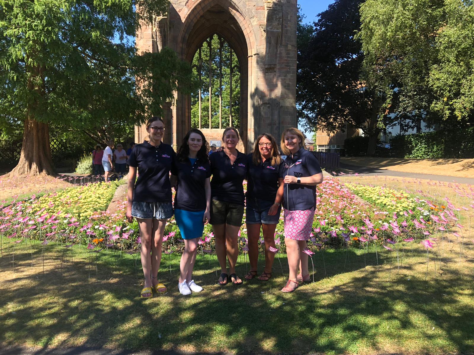 A group of volunteers from Spontex stand together at the Celebration Garden installation.