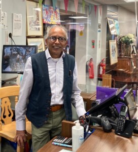 Shakeel stands behind the till in the hospice's shop in Lowesmoor, Worcester.