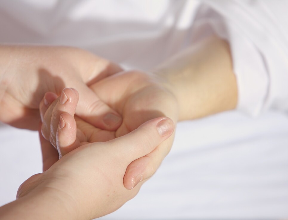 Two hands hold another person's hand, demonstrating the M Technique.