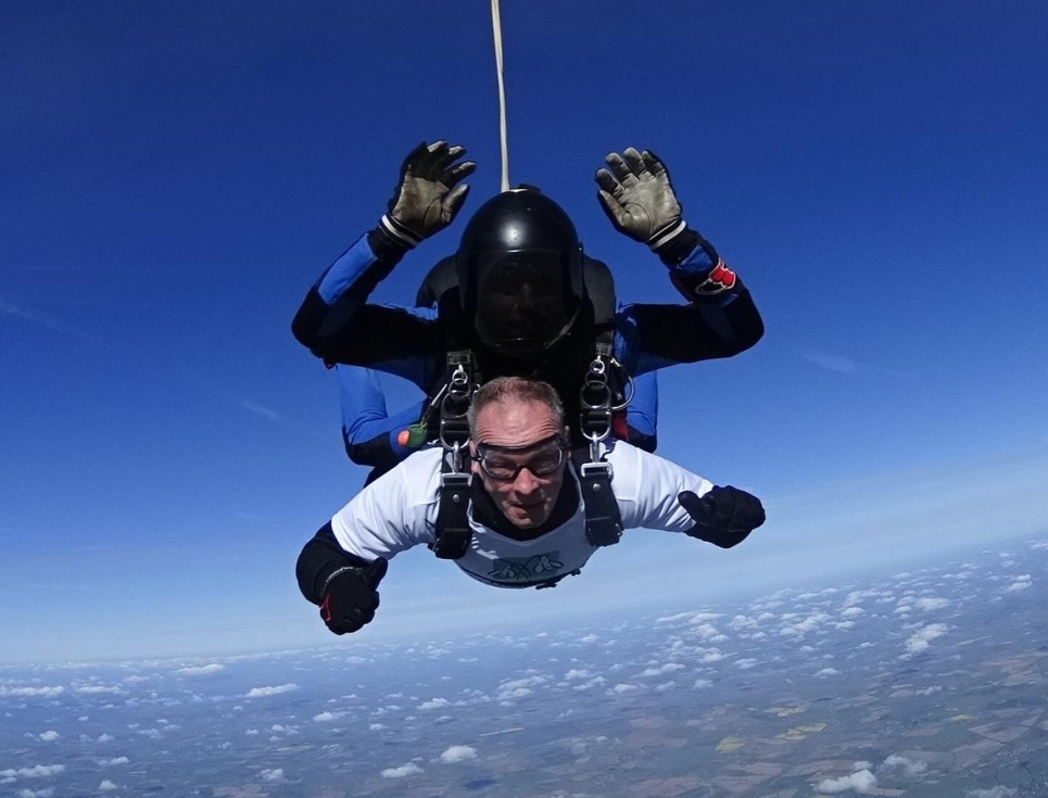A male skydiver free falling through the air with an instructor.