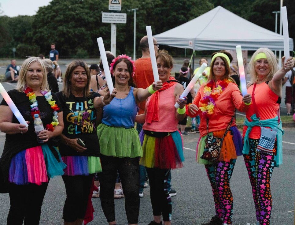 Group of women in multi colour tutus with glow sticks