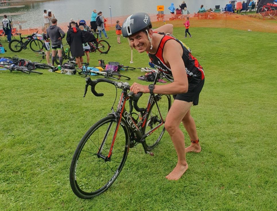 A man pushing a bike up a hill, during a triathlon.