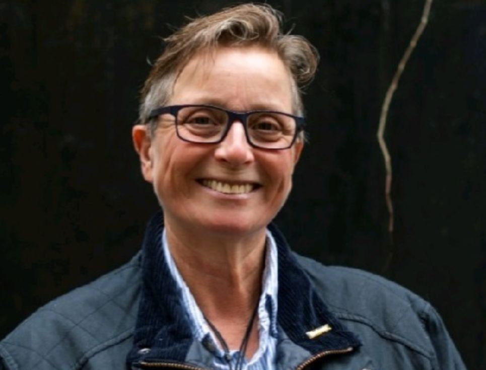 A woman with brown short hair and glasses smiling