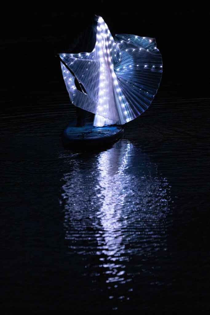 A paddleboarder wearing light-up wings creates a sparkling spectacle on the lake at Croome Court.