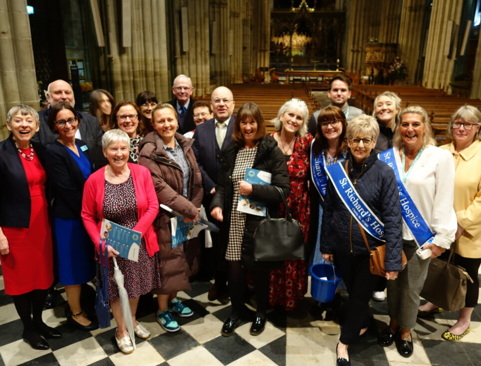 A large group of people standing together for a photo inside Worcester Cathedral.