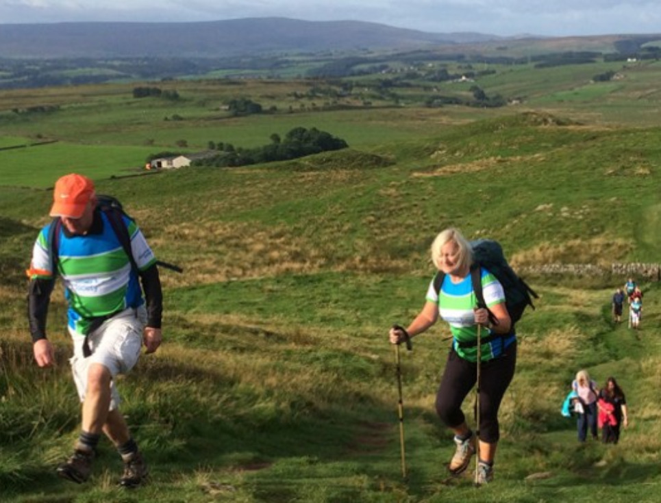 A group of walkers trekking along Hadrian's Wall