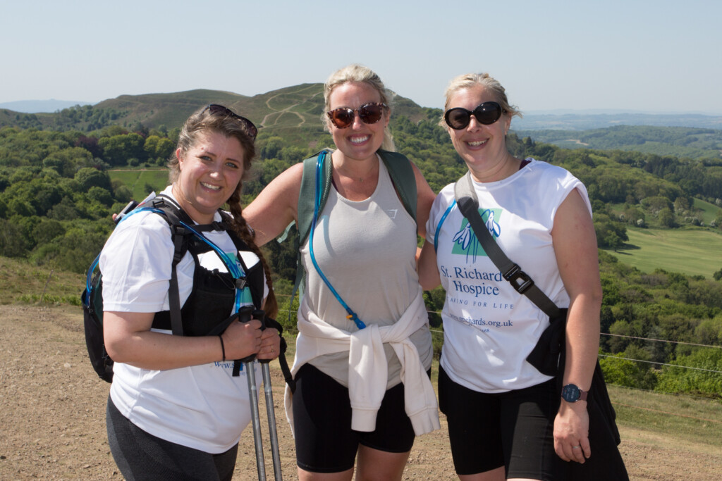 Three people on the Malvern Hills in the sunshine.