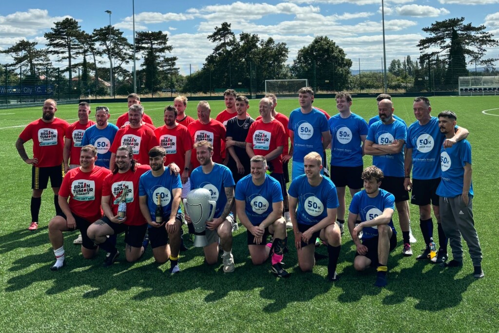 A group of people on a football pitch wearing blue and red t-shirts.