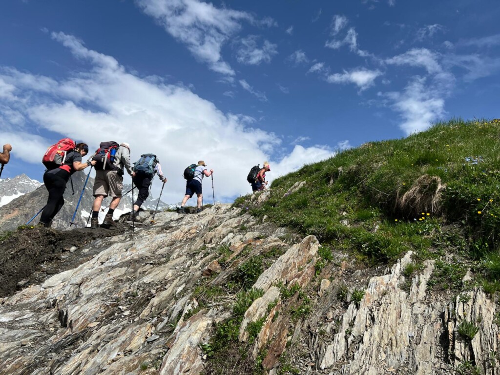 A group of walkers hike up a steep slope